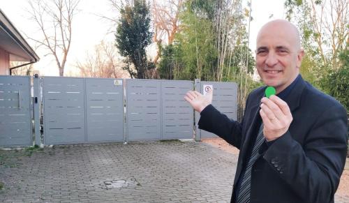 a man holding a green object in front of a gate at Hotel Ristorante alla Campagna in San Giovanni Lupatoto
