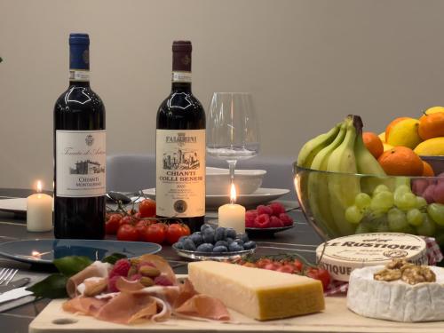 フィレンツェにあるVilla Aria - Firenze Settignanoのワイン2本(フルーツ付きのテーブルに座って)