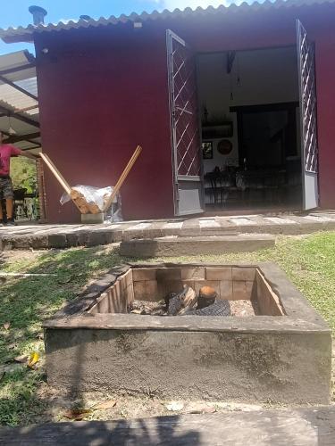 a stone fire pit in front of a house at Refúgio Atlântico in Mogi das Cruzes