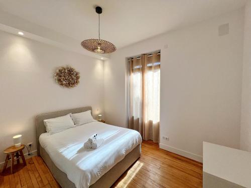 une chambre avec un lit blanc et une fenêtre dans l'établissement L'Enlumineur - Centre - Luxe - Balcon - Climatisation, à Toulouse