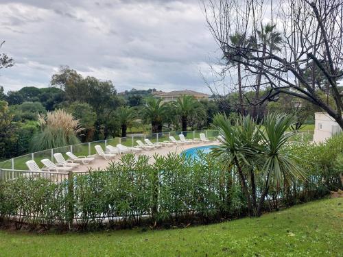 - un groupe de chaises et une piscine dans une cour dans l'établissement Bagatelle Studio 3étoiles rez de jardin Axelle LocAppart, à Mandelieu-la-Napoule