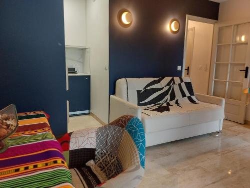 une chambre avec un lit et une chaise dans une pièce dans l'établissement Bagatelle Studio 3étoiles rez de jardin Axelle LocAppart, à Mandelieu-la-Napoule