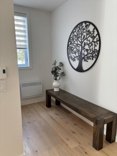 a room with a wooden bench and a tree on the wall at Le 800 de St-Jovite in Mont-Tremblant