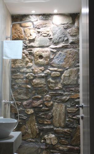 a stone wall in a bathroom with a sink at Old Stone Hotel Skopje in Skopje