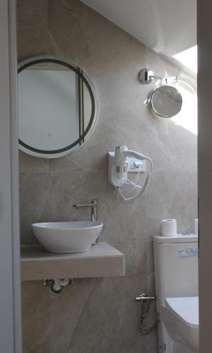a bathroom with a sink and a mirror on the wall at Old Stone Hotel Skopje in Skopje