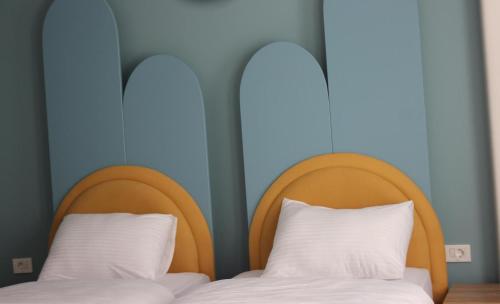 two beds with wooden headboards in a room at Old Stone Hotel Skopje in Skopje