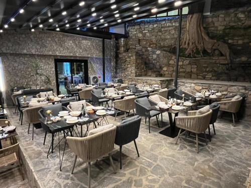 a restaurant with tables and chairs and a stone wall at Old Stone Hotel Skopje in Skopje