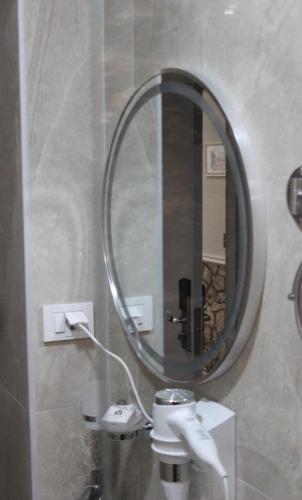 a bathroom with a round mirror and a sink at Old Stone Hotel Skopje in Skopje