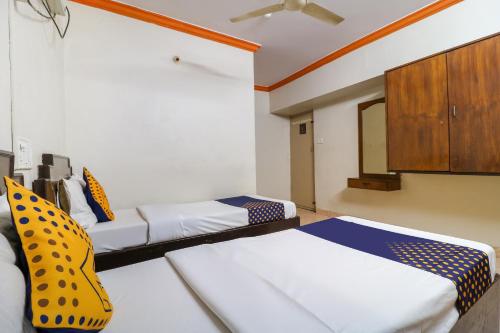 a room with two beds and a cabinet at SPOT ON Balaji Residency near Yeshwantupur Railway Station in Bengaluru