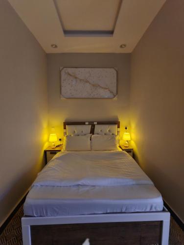 a bedroom with a bed with two lamps on it at مرفق الشلال السياحي in Jeddah