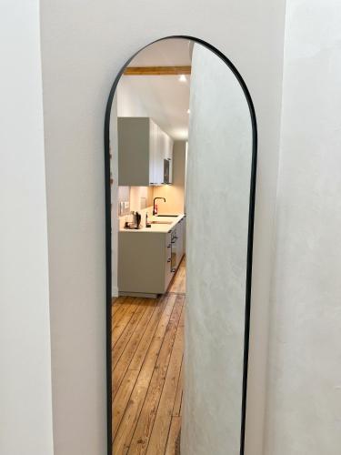 un miroir ovale dans un couloir avec une cuisine dans l'établissement Le Vigneron - Centre - Luxe - Climatisation, à Toulouse