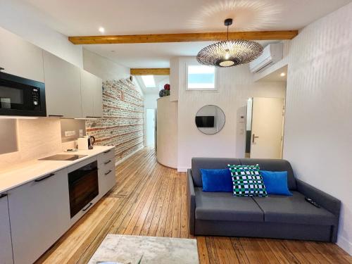 un salon avec un canapé et une cuisine dans l'établissement Le Vigneron - Centre - Luxe - Climatisation, à Toulouse