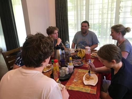 a group of people sitting around a table eating food at El Tessa garden/serviced apartment in Kisumu