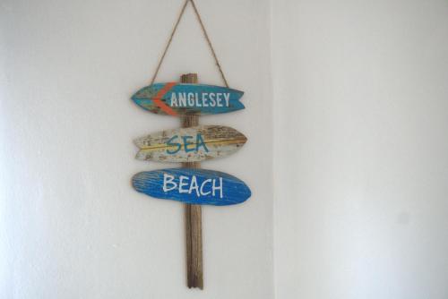 a group of three beach signs hanging on a wall at 3BDR Town House in the Heart of Holyhead - Free Onsite Parking in Holyhead