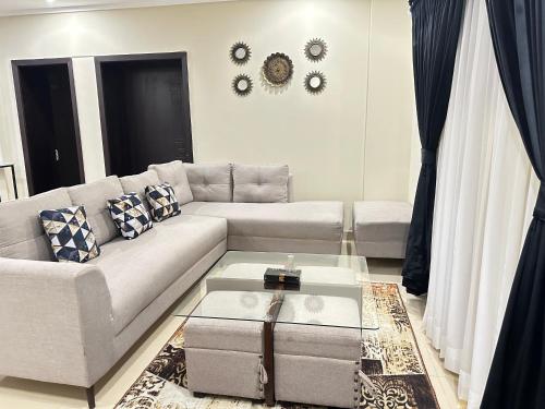a living room with a couch and a table at Entire 2-Bed Apartment Best For Families and Friends in Islamabad