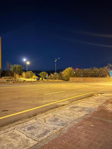 an empty parking lot at night with street lights at Entire 2-Bed Apartment Best For Families and Friends in Islamabad