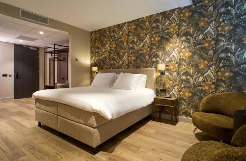 a bedroom with a large bed and a floral wallpaper at Eilandhotel Texel - Nieuw geopend hotel in De Cocksdorp