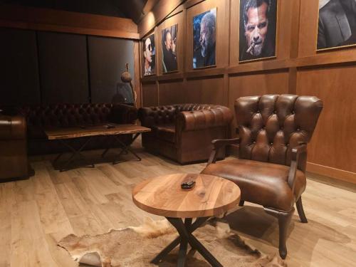 a living room with a leather chair and a table at Grand Chamois Hotel & Spa in Mavrovo