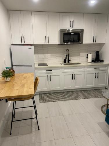 a kitchen with white cabinets and a refrigerator and a table at Cozy tiny home in Cape Coral
