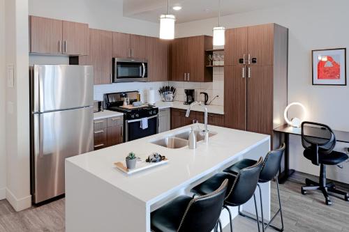 a kitchen with a large white island with black chairs at Designer - by Convention Center Pool, HTub, 24-7 Gym in Salt Lake City