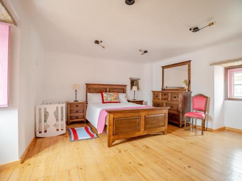 a bedroom with a bed and a desk and a mirror at Casa das bonecas in Pernigem