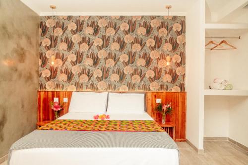 a bedroom with a bed with a floral wallpaper at Eden Valley Ecolodge and Farming in Madalena
