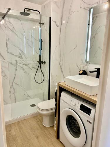 une salle de bain avec douche et machine à laver dans l'établissement Super Comfy Port Fréjus Piscine 2 chambres 6 personnes, à Fréjus