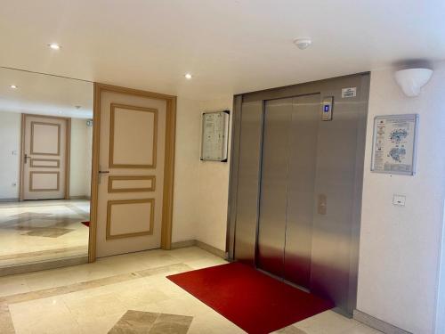 un couloir avec deux portes et un tapis rouge dans l'établissement Super Comfy Port Fréjus Piscine 2 chambres 6 personnes, à Fréjus