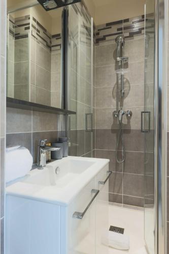 une salle de bain avec un lavabo et une douche dans l'établissement Studio 2P Roland Garros Parc des, à Boulogne-Billancourt