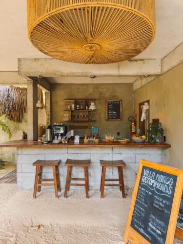 a bar with three wooden stools in front of it at Villa Mango Jeri in Jericoacoara