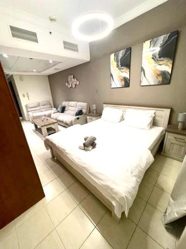 a bedroom with a large bed and a living room at Ultra Luxury Chic Studio in JLT in Dubai