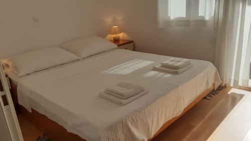 a bedroom with a bed with two towels on it at Apartment Dobri in Batalaži