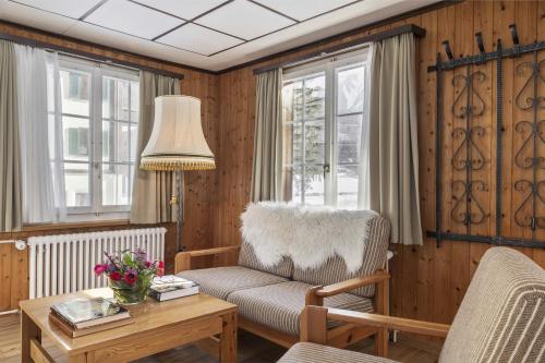 a living room with a chair and a table at Chalet by Hotel Bad Serneus in Klosters