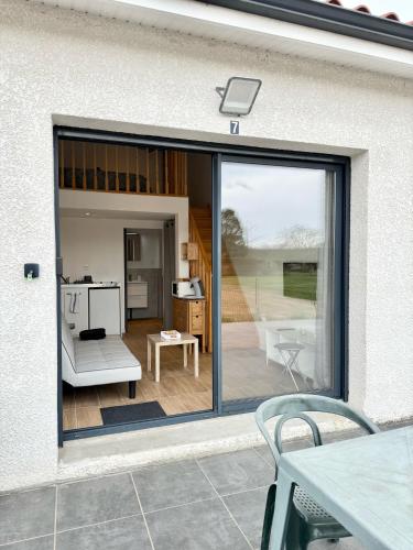 une porte coulissante en verre d'une terrasse avec une table. dans l'établissement Studio Confort - Proche MEETT 300m, à Cornebarrieu