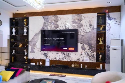 a living room with a tv on a wall at ABOT Luxury Homes in Lekki