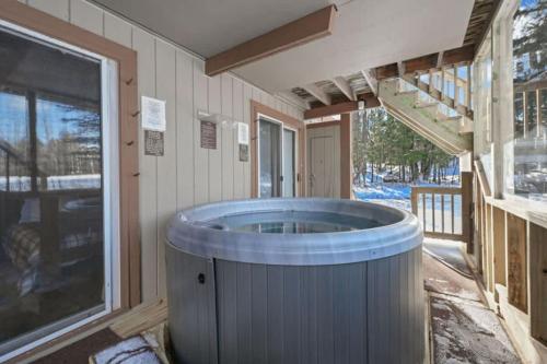 a jacuzzi tub in a house with a porch at Premium Slope-Side Escape I Alpen Villas at Powderhorn Mountain in Bessemer