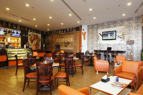 a restaurant with tables and chairs and a bar at Golden Tulip Hail in Hail