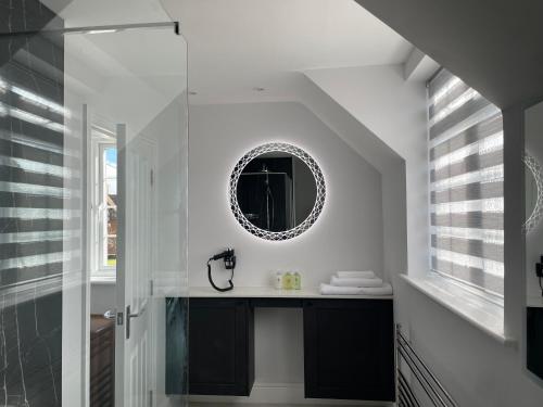 a bathroom with a sink and a mirror at Happy Hinwood House, Hampshire! in Stockbridge