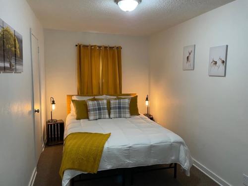 a bedroom with a bed with a yellow curtain at Downtown Yellow Room at Villages on Aurora in Ironwood