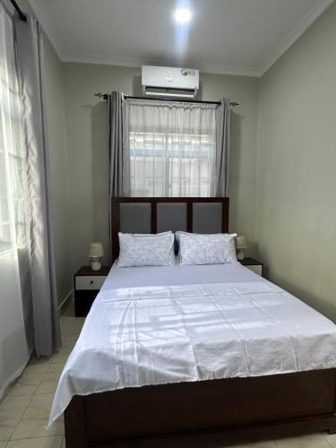 una camera da letto con un grande letto e un piumone bianco di Blue wave loft a Dar es Salaam