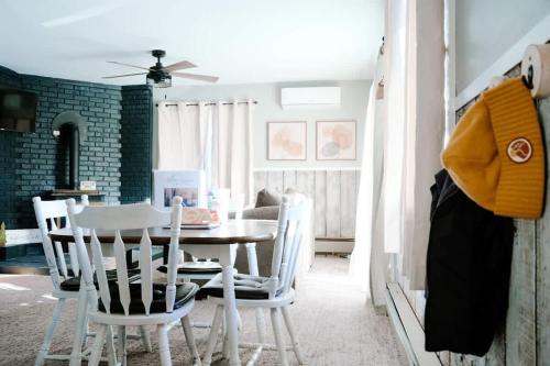 a dining room with a table and white chairs at Charming Ski Chalet at Powderhorn Mountain in Bessemer