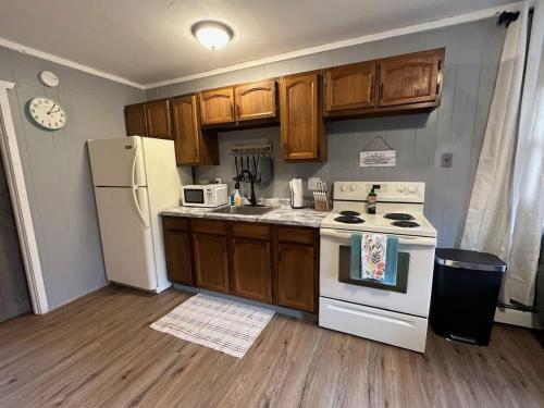 a kitchen with wooden cabinets and a white refrigerator at Snowbound Bliss at Powderhorn Mountain in Bessemer