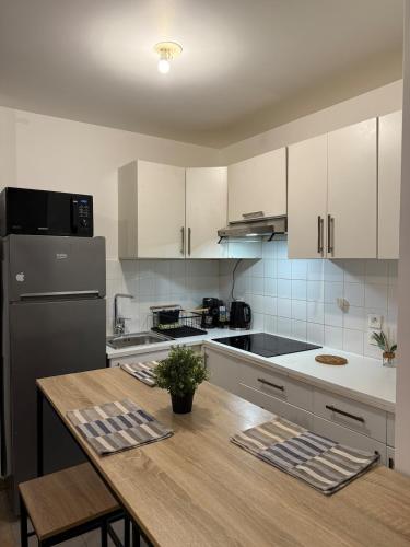 une cuisine avec des armoires blanches et une table en bois dans l'établissement Studio Évasion, aux Lilas