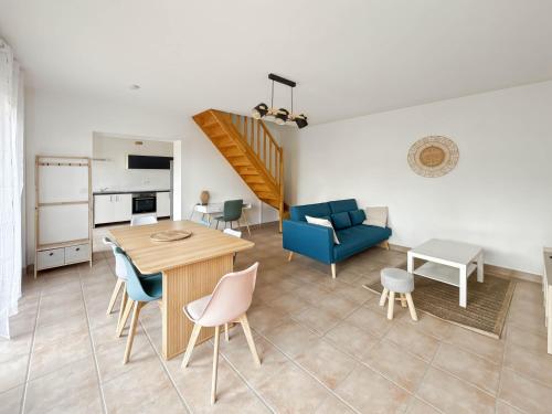 a living room with a table and a blue couch at Le refuge in Montoire-sur-le-Loir