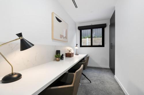an office with a white desk with chairs and a lamp at 5 Ensuite Luxury Holiday House Balwyn North in Melbourne