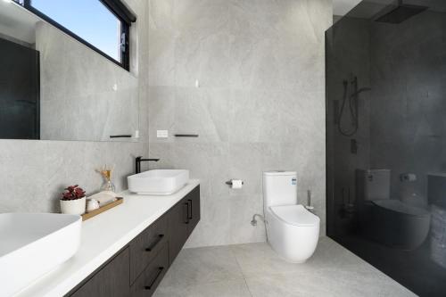 a bathroom with a toilet and a sink and a mirror at 5 Ensuite Luxury Holiday House Balwyn North in Melbourne