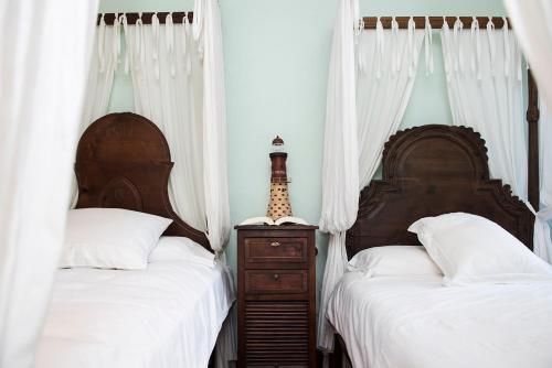 two beds in a bedroom with white curtains and a dresser at LUXURY CELAVELLA GALICIA Hc in Baiona