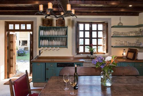 a kitchen with green cabinets and a table with flowers at LUXURY CELAVELLA GALICIA Hc in Baiona