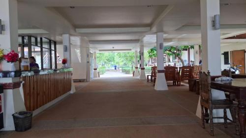 een gang van een restaurant met tafels en stoelen bij Lanta Summer House 1 in Koh Lanta
