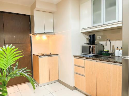 a kitchen with a sink and a microwave at Prime 1br Condo Infront Grand Hyatt BGC #oursw20d1 in Manila